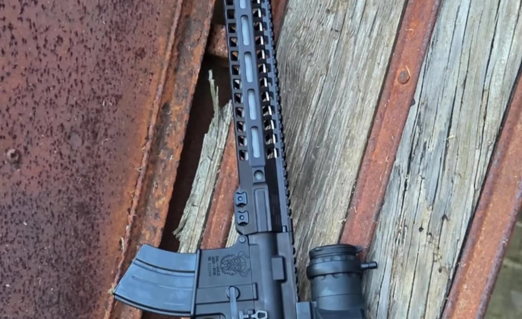 Rifle handguard, receiver, magazine, and optic shown outdoors